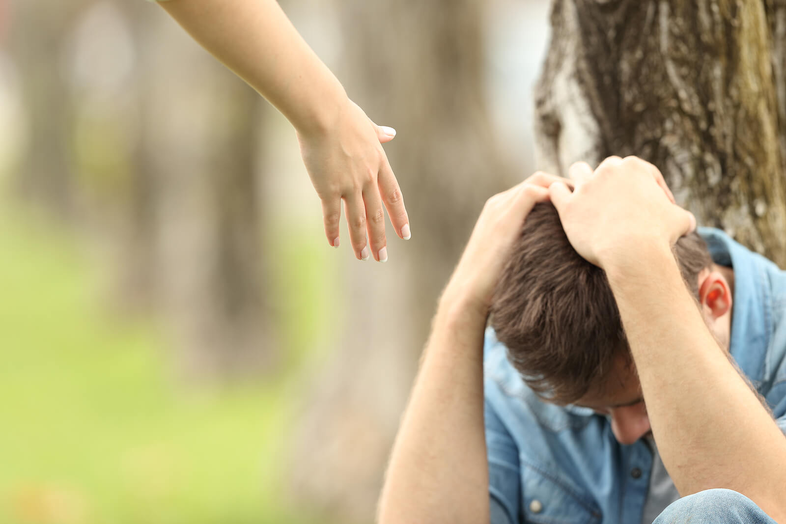 Image of a hand reaching down to someone who needs depression help. Representing what to do for depression when you are experiencing symptoms. Friends, family, and a depression therapist in Baltmore, MD can provide support.